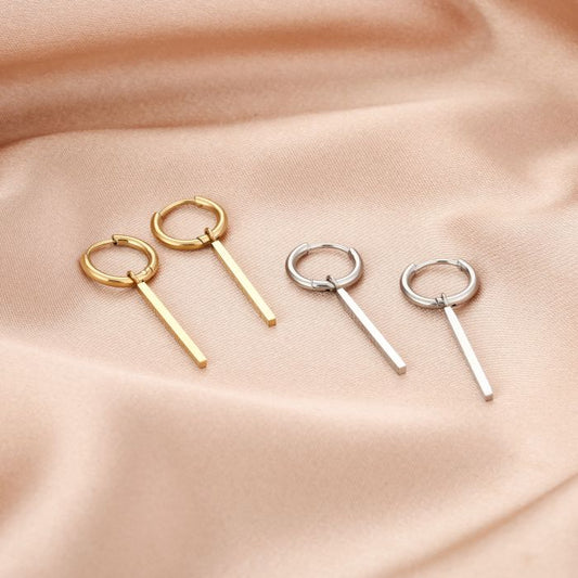 Oorbellen met lang vierkant staafje detail close-up goud en zilver kleur