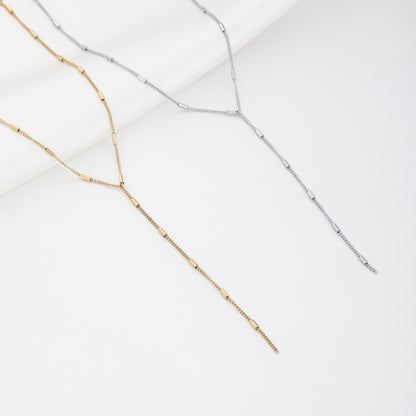 Goud en zilver kleurige Y-ketting witte achtergrond